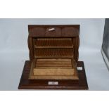 A 1930s oak cigarette and cigar box having internal compartments and cantilever action.