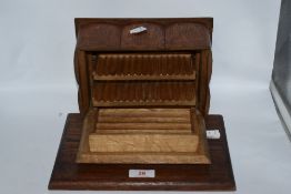 A 1930s oak cigarette and cigar box having internal compartments and cantilever action.