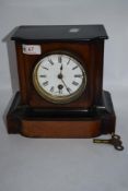 An antique mahogany cased mantel clock having enamel face with Roman numerals (AF) with key.