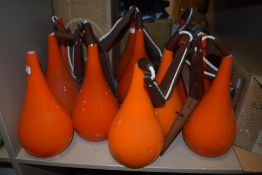 A collection of 1970sDanish designed orange glass wall lights and spare shades, having teak mounts.