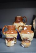 A collection of earthen ware jugs having relief designs, including hall marked silver edged examples