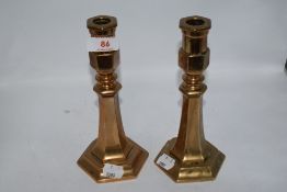 A pair of interesting antique brass candlesticks, W M and S etched to faceted side, appear to have