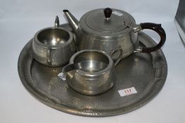 A vintage hammered pewter tea pot, tray, sugar basin and jug.