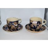 Two 19th century oversized cups and saucers, having floral pattern in blue and rust tones,
