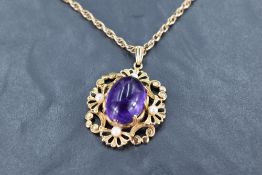 An amethyst cabochon pendant having seed pearl decoration to scrolled 9ct gold mount on a 9ct gold