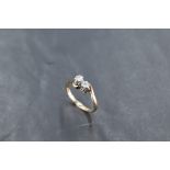 A two stone diamond ring, total approx 0.25ct in claw set mounts with crossover shoulders on a 9ct