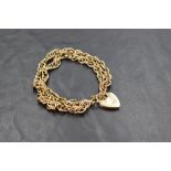 A 9ct gold double-strand bracelet with heart-shaped padlock clasp, marked 375 to clasp, 27grams