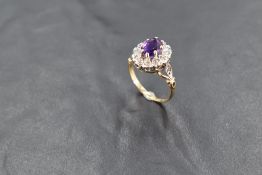 A heat treated amethyst and diamond chip cluster ring in illusionary setting to open shoulders on