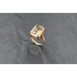 A large emerald cut citrine ring having a four claw mount on a 9ct gold loop, size L & approx 4.4g