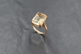 A large emerald cut citrine ring having a four claw mount on a 9ct gold loop, size L & approx 4.4g