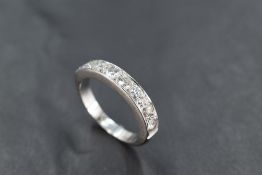 An 18ct white gold half eternity ring, having a linear arrangement of seven diamond brilliants