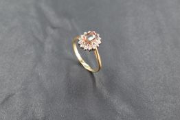 An 18ct gold andalusite and diamond cluster ring, the central raised oval-cut stone within a