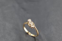 A diamond trilogy ring, total approx 0.35ct having crossover shoulders on a yellow metal loop, marks