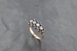 A quadruple sapphire and diamond cluster ring in a raised basket mount on a 9ct gold loop, size