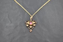 An Edwardian 9ct gold, pink stone and seed pearl pendant, having central oval-cut pink stone