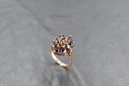 An oval garnet cluster ring on a 9ct gold loop, size O & approx 5.2g