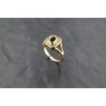 A 9ct gold sapphire and diamond ring, having a central raised oval-cut sapphire within a rubbed-over