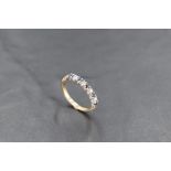 A diamond and sapphire half eternity ring having moulded shoulders and a 9ct gold loop, size K &