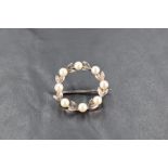 A 9ct white gold and seed pearl garland brooch, approx 25mm diameter & 3g