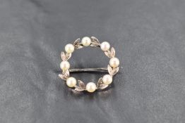 A 9ct white gold and seed pearl garland brooch, approx 25mm diameter & 3g