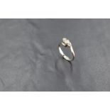 A diamond trilogy ring, total approx 0.35ct having cross over shoulders on a white metal loop