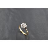 A diamond daisy cluster ring, total approx 0.5ct in a raised claw mount to knife blade shoulders