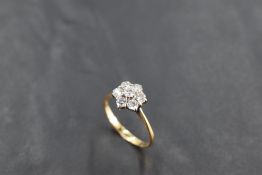 A diamond daisy cluster ring, total approx 0.5ct in a raised claw mount to knife blade shoulders