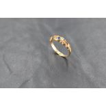 A powder blue sapphire and diamond chip set band ring having a scrolled mount on an 18ct gold