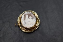 A large Victorian conch shell cameo brooch depicting a courting couple scene with cupid