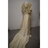 An Edwardian white silk dress having long sleeves, ruffled georgette and lace to neckline, full