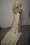 An Edwardian white silk dress having long sleeves, ruffled georgette and lace to neckline, full