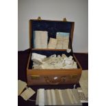 A leather suitcase containing an extensive amount of varied antique lace, trimmings, edgings and