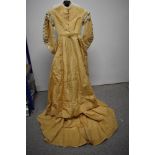 A Victorian cream silk dress having tassel trim to bodice, tape work to neck and sleeves and