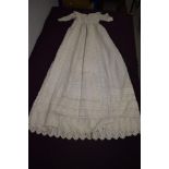 A Victorian christening gown having intricate embroidery and pin tucks throughout.