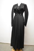 An Art Deco black satin evening gown having sequinned embellishments to top of bodice and waist, tie