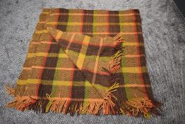A large vintage Otterburn rug, in a brown, beige, red and green colourway, some wear and a few small