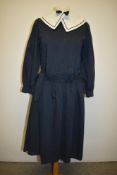 A retro navy blue sailor style dress having white collar, drop waist with tie details and long