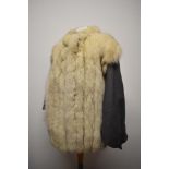 A 1980s grey leather jacket having white fox fur trim to front and back.