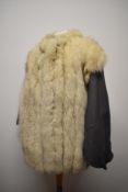 A 1980s grey leather jacket having white fox fur trim to front and back.