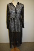 A late 1930s sheer lace black dress having full length sleeves gathering into a fitted cuff, press
