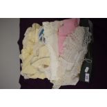 A box full of babies and children's clothing, beautifully detailed dresses and gowns, coats etc.