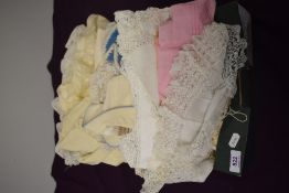 A box full of babies and children's clothing, beautifully detailed dresses and gowns, coats etc.