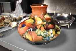 A mid 20th century Moorcroft pottery squat form vase tube lined in the Orchid pattern with a