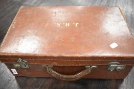 An early 20th century leather bound travel trunk or suitcase.