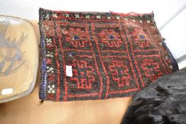 A 20th century Persian Afghan Balouch saddle bag in woven wool in a black and red ground 110cm x