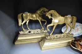 A pair of mirrored Victorian brass door stops or fire ornaments in the form of horses.