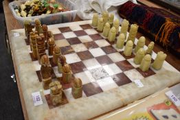 A 1970's carved Onyx chess set with inlaid stone board.