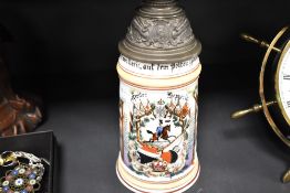 A German porcelain tankard with pewter mounted lid marked Ladan Darmstadt with enamel decoration