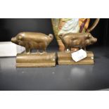 A pair of small bronze cast mirrored pig ornaments