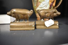A pair of small bronze cast mirrored pig ornaments